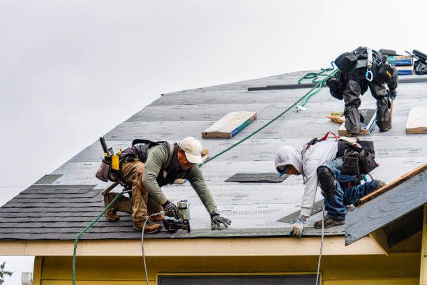 Roofer installing shingles on a residential roof